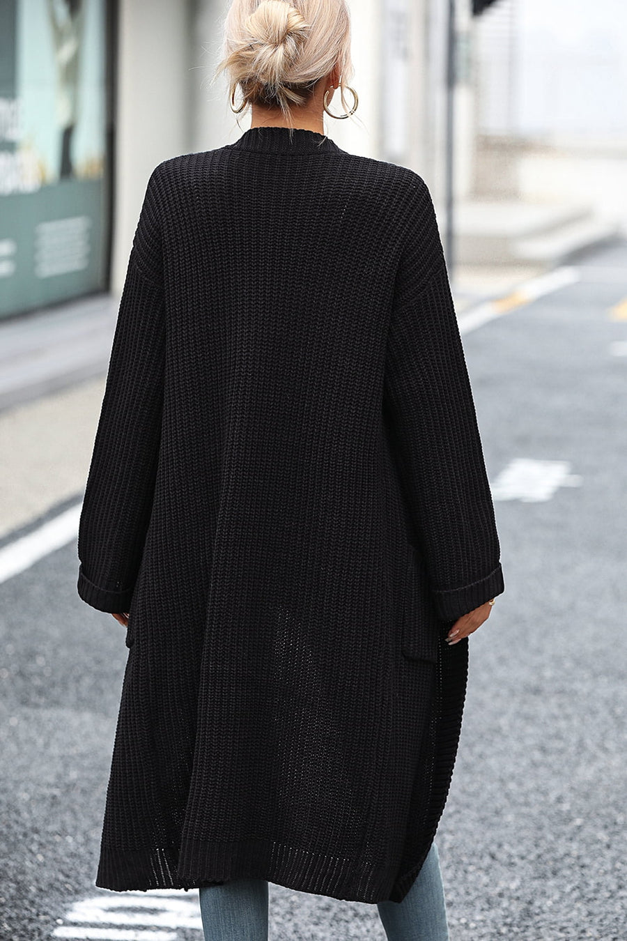 Black longline knit cardigan with pockets and a relaxed fit.