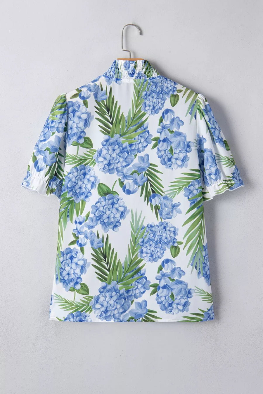 White short sleeve blouse with blue hydrangea floral print and smocked collar.
