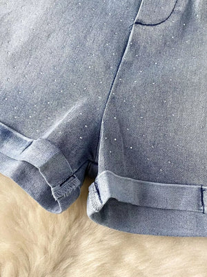 Blue denim romper with rhinestone embellishments and cuffed hems.