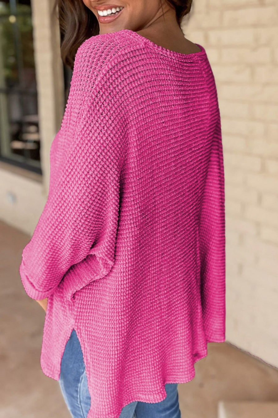Hot Pink waffle knit V-neck sweater with slit hem and long sleeves.