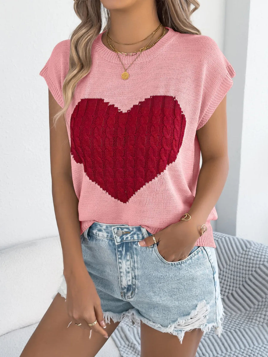Blush pink cable knit sweater vest with a large red cable knit heart graphic.