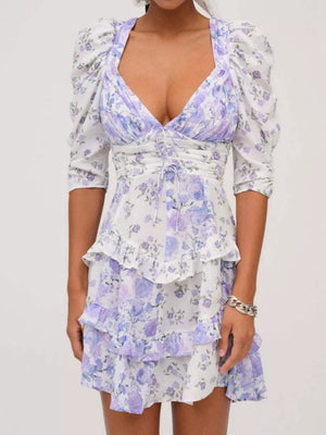 Ruched floral tie-front dress with puff sleeves and tiered ruffles in purple and white.