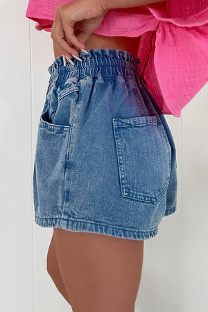 Medium wash denim shorts with paperbag waist and relaxed fit.