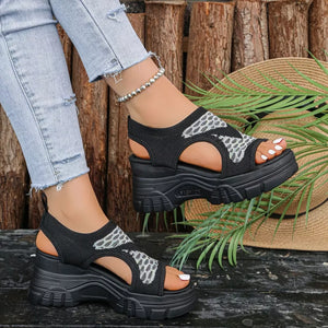 Black open-toe platform sandals with geometric pattern and chunky sole.