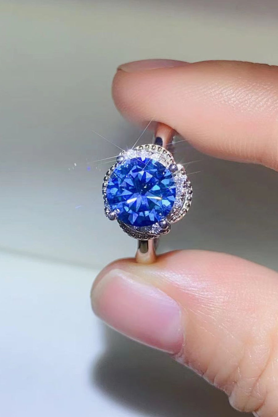 Blue moissanite cocktail ring with a halo of small diamonds.