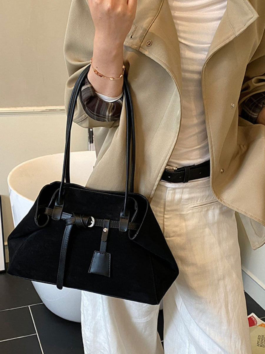 shoulder bag in black featuring buckle detail and structured fit