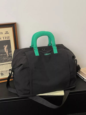 Black nylon travel bag with green padded handles and adjustable strap.