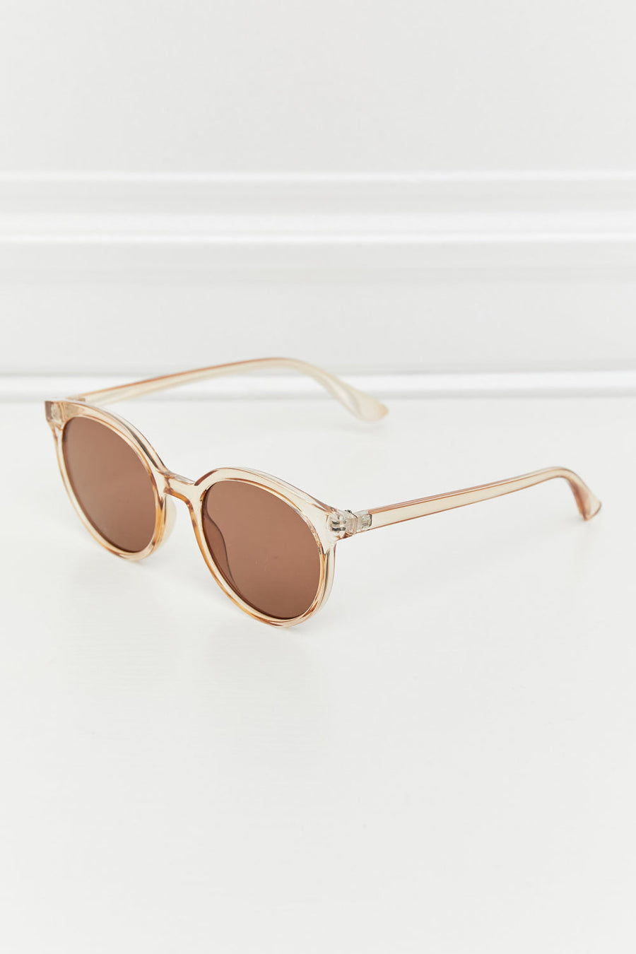 Tortoiseshell round frame sunglasses with tan translucent frames and brown lenses.