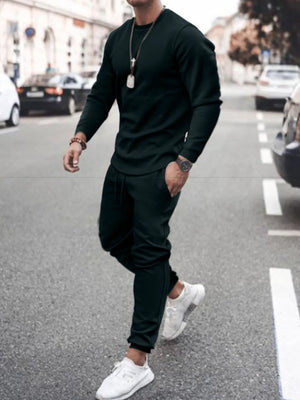Men's black textured loungewear set with crewneck sweatshirt and drawstring pants.