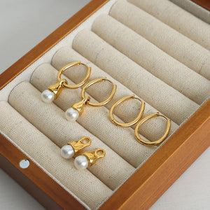 Gold oval hoop earrings with pearl drops and separate pearl charms.