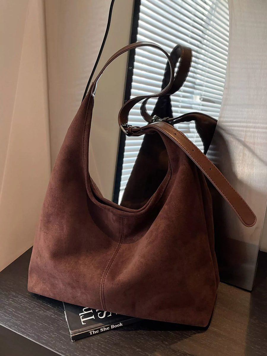 Brown suede hobo bag with adjustable strap and leather trim.