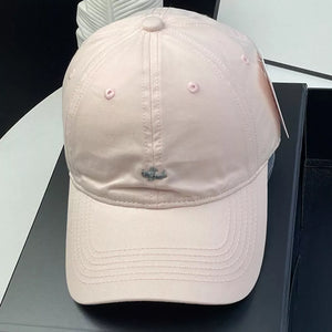 Pink cotton baseball cap with embroidered detail and ventilation eyelets