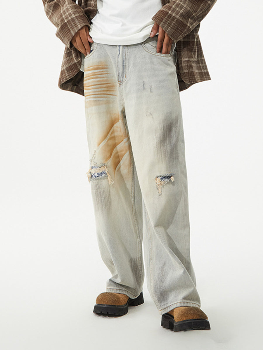 Light wash distressed wide-leg jeans with unique graphic patches and ripped details.