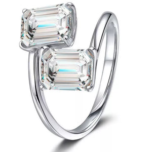 Emerald-cut moissanite bypass ring in silver with two clear stones.