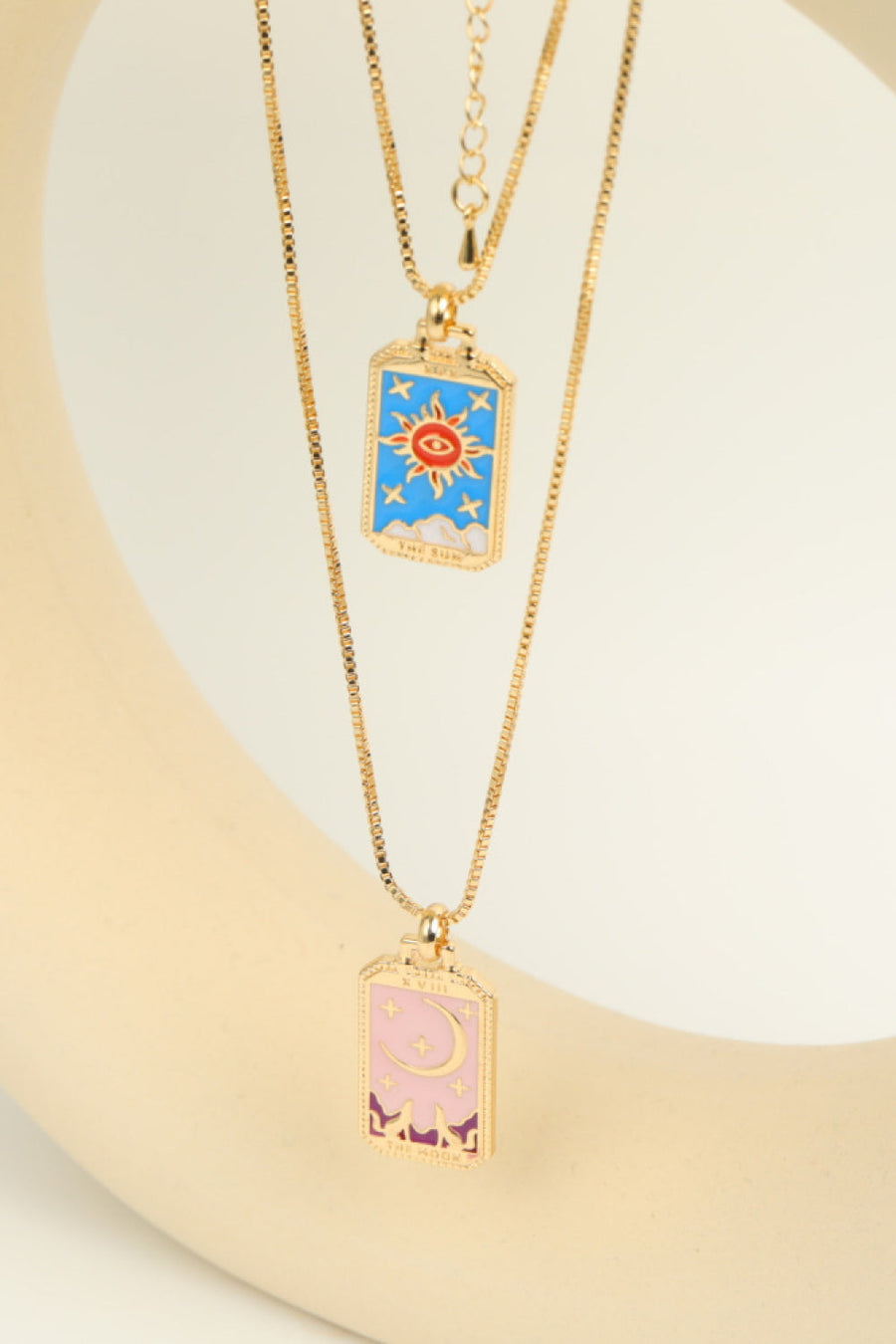 Celestial tarot pendant necklace set with sun and moon charms in gold-tone copper.