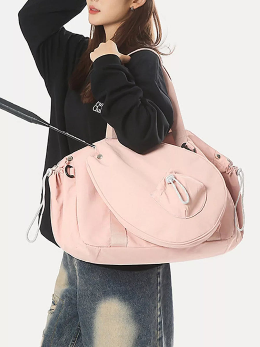Pink athletic nylon tote bag with racket holder and cinch-cord closure.