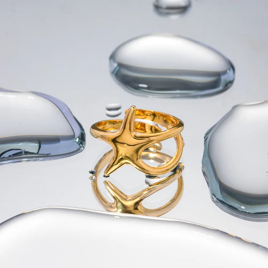 Gold starfish silhouette adjustable ring with open band detail.