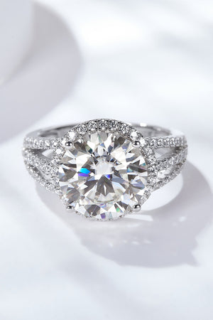 Silver split shank halo engagement ring with large center stone and pavé band.