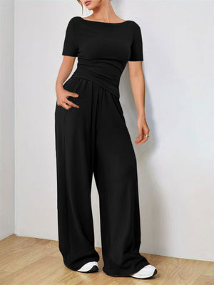 Black boat neck jersey co-ord set with wide leg pants and a draped waist detail.