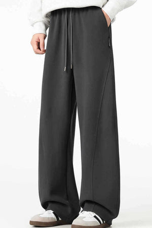 Men's black relaxed wide-leg sweatpants with drawstring and side seams.