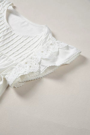 White cotton shirt with lace flutter sleeves and pleated front detail.