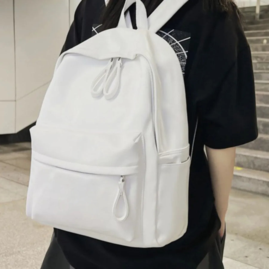 White leather backpack with front zip pocket and dual zip main compartment.