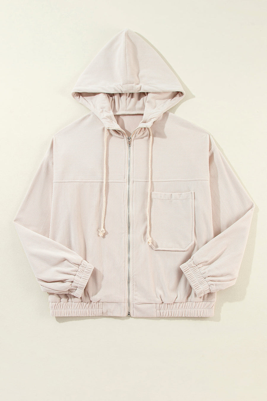Cream corduroy bomber hoodie with relaxed fit, zip front, drawstring hood, chest pocket and elastic cuffs.