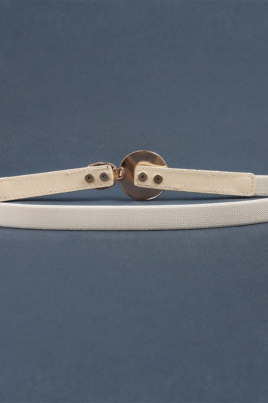 Ivory elastic waist belt with a circular disc detail and gold-tone buckle.