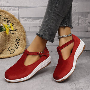 Red T-bar flat slip-ons with adjustable strap and white sole.
