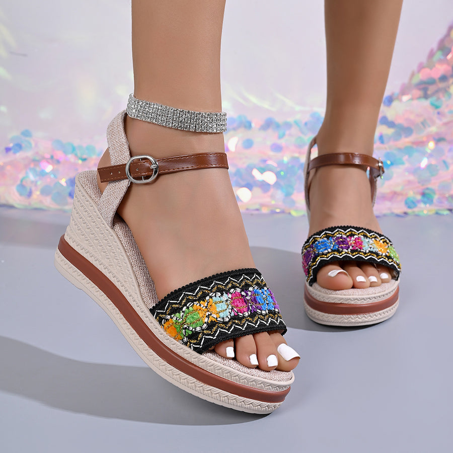 Embroidered floral wedge sandals with adjustable strap and brown ankle strap.