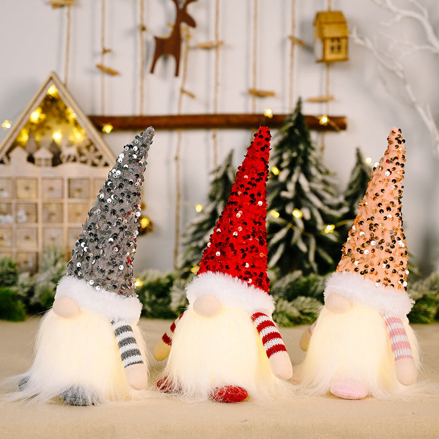 Light-Up Sequin Gnome Trio in dark gray, red, and blush pink with fuzzy beards and striped arms.