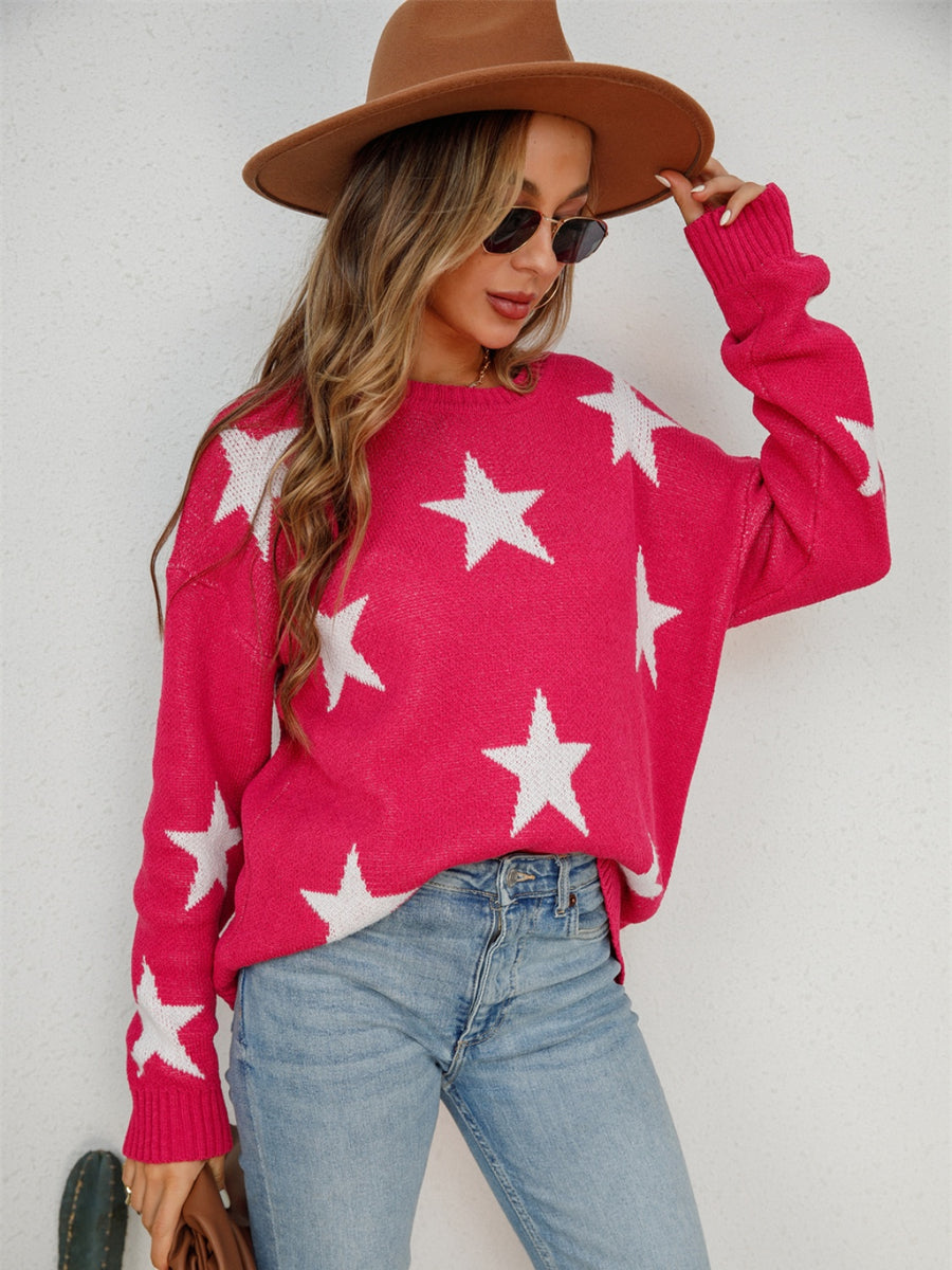 Pink crewneck sweater with white stars, long sleeves, and ribbed cuffs.