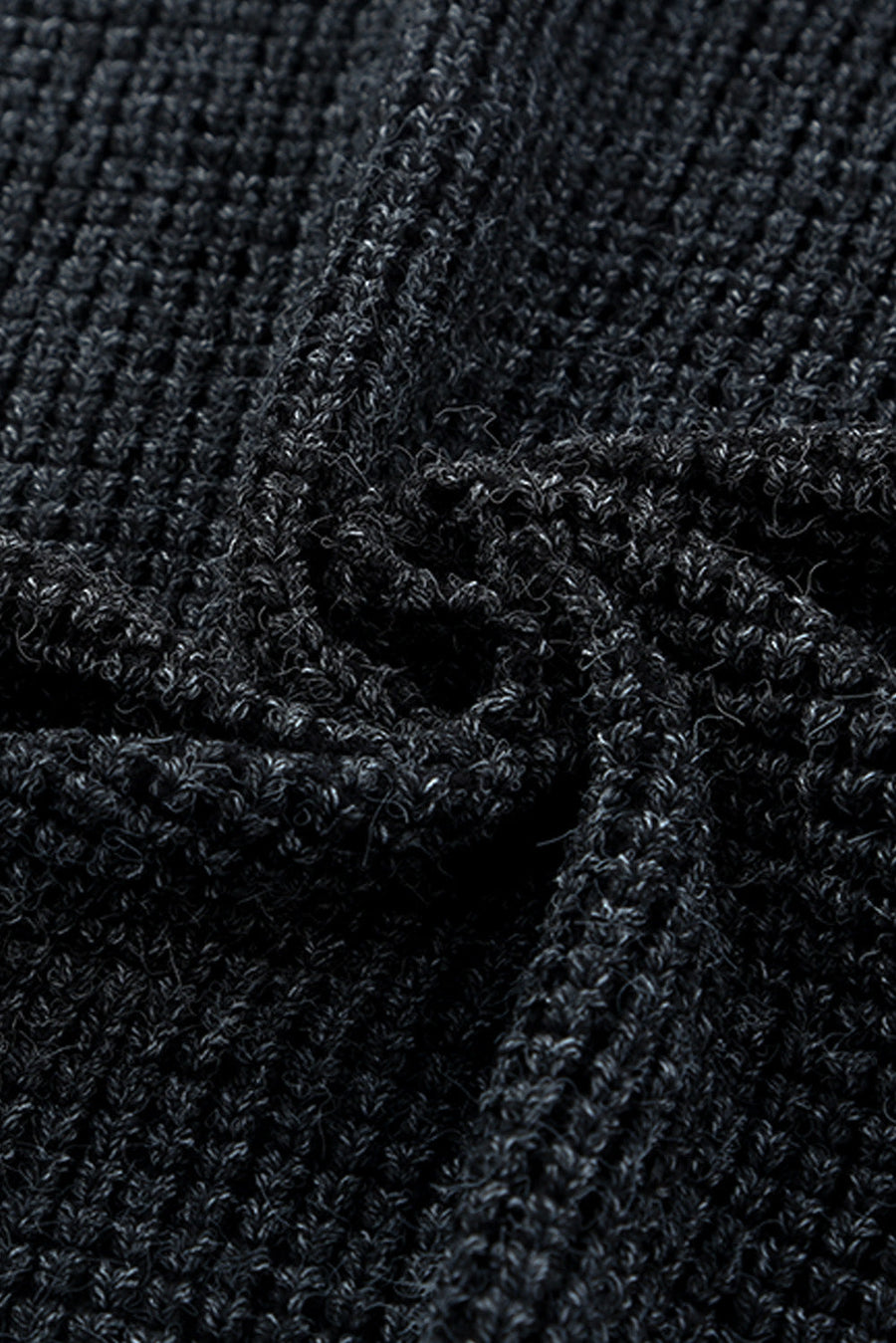 Textured black acrylic knit cardigan detail