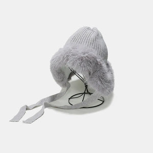 Gray knit trapper hat with faux fur trim and ties.