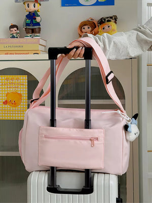 Blush pink travel bag with adjustable strap and front zippered pocket.