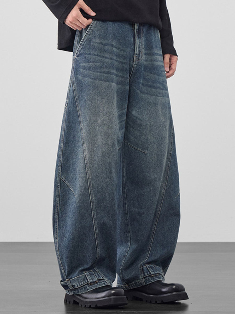 Men's baggy vintage wash jeans in dark blue denim with cinched hems.