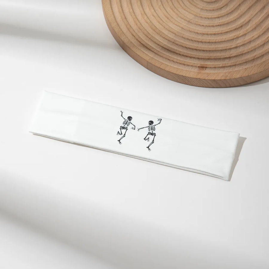 White headband with black dancing skeleton graphic