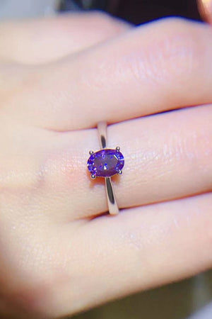 Oval cut amethyst solitaire ring with silver band.