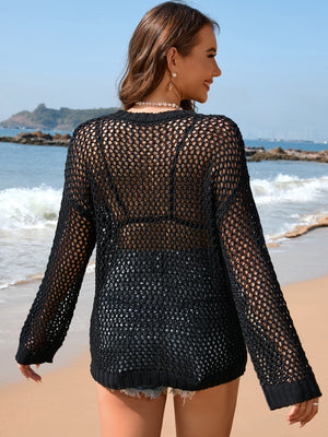 Black open-knit pullover sweater with long sleeves and crew neck, styled over shorts.