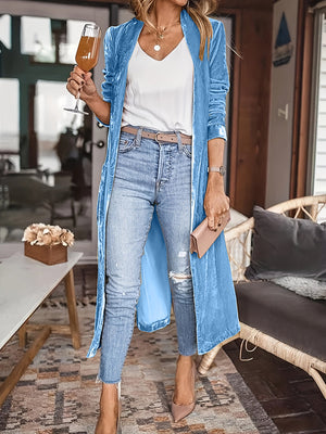 Blue velvet duster coat with fluid silhouette, open front, long sleeves, and a long hem.