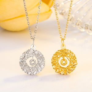 Sterling silver plated pendant necklace in gold and silver with intricate circular design.