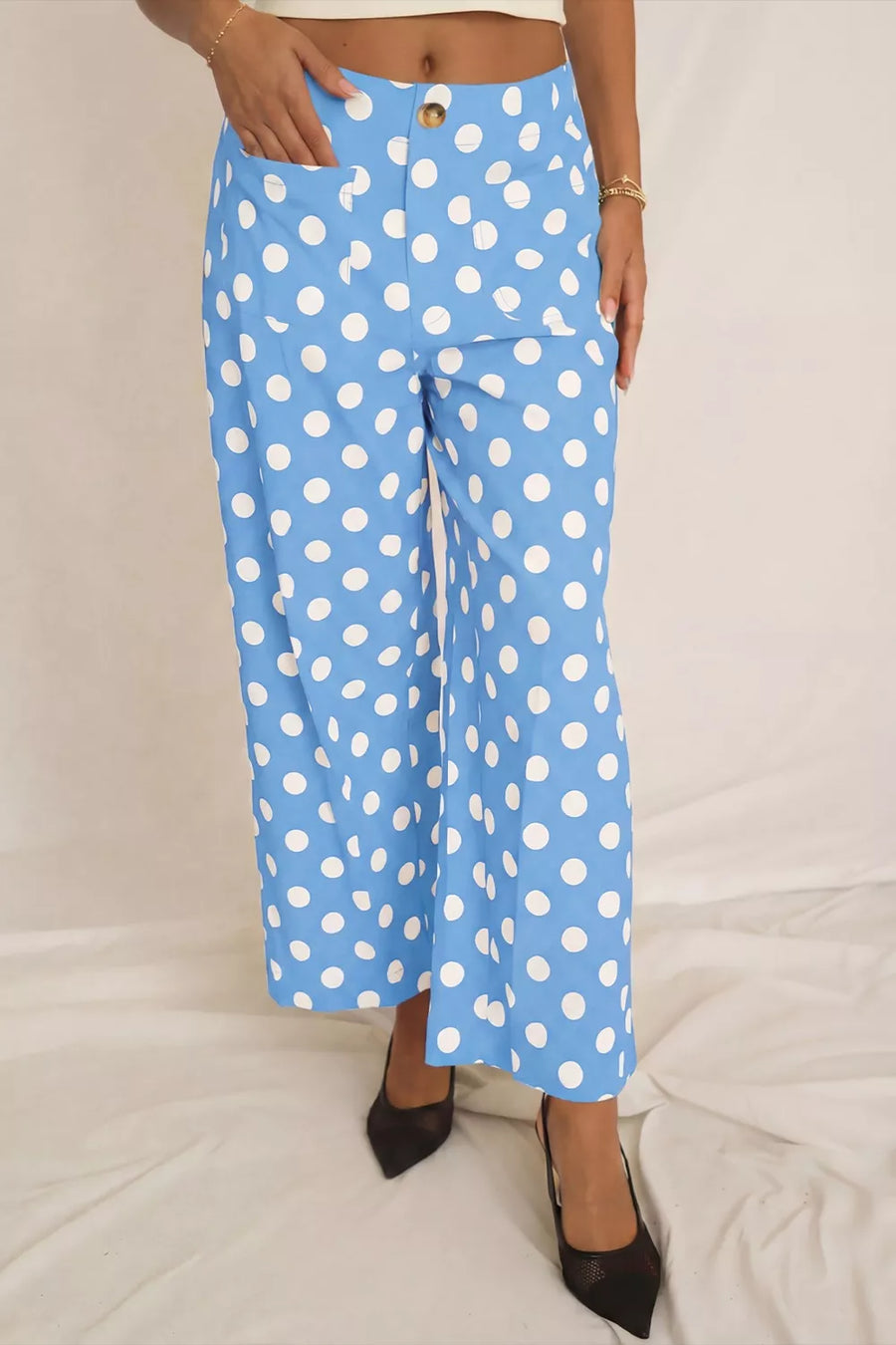 Blue polka dot cropped pants with pockets and a button closure.
