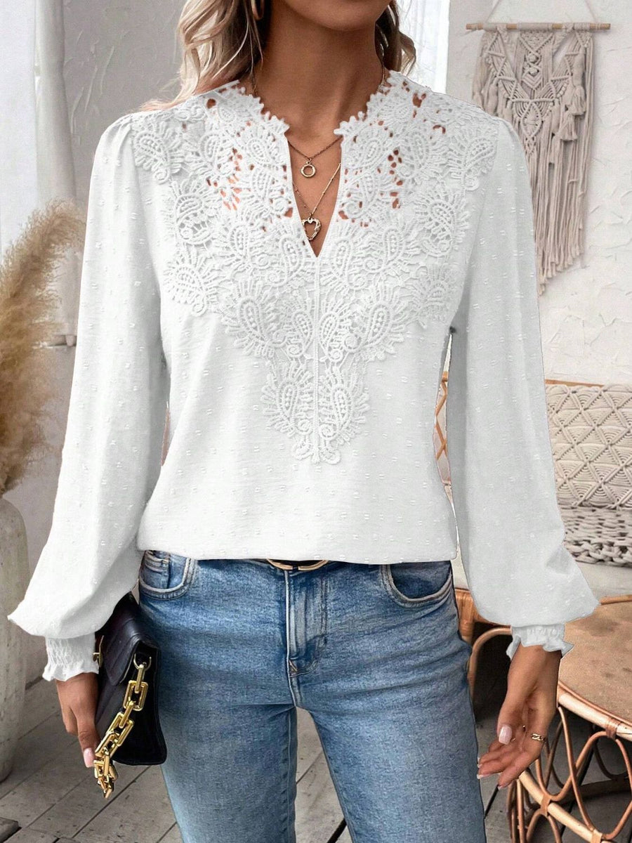 White embroidered yoke blouse with puff sleeves and textured fabric.