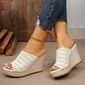 Beige perforated espadrille wedge sandals with woven wedge detail.