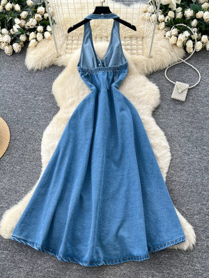 Blue denim A-line dress with V-neck, halter straps, and button placket detail.