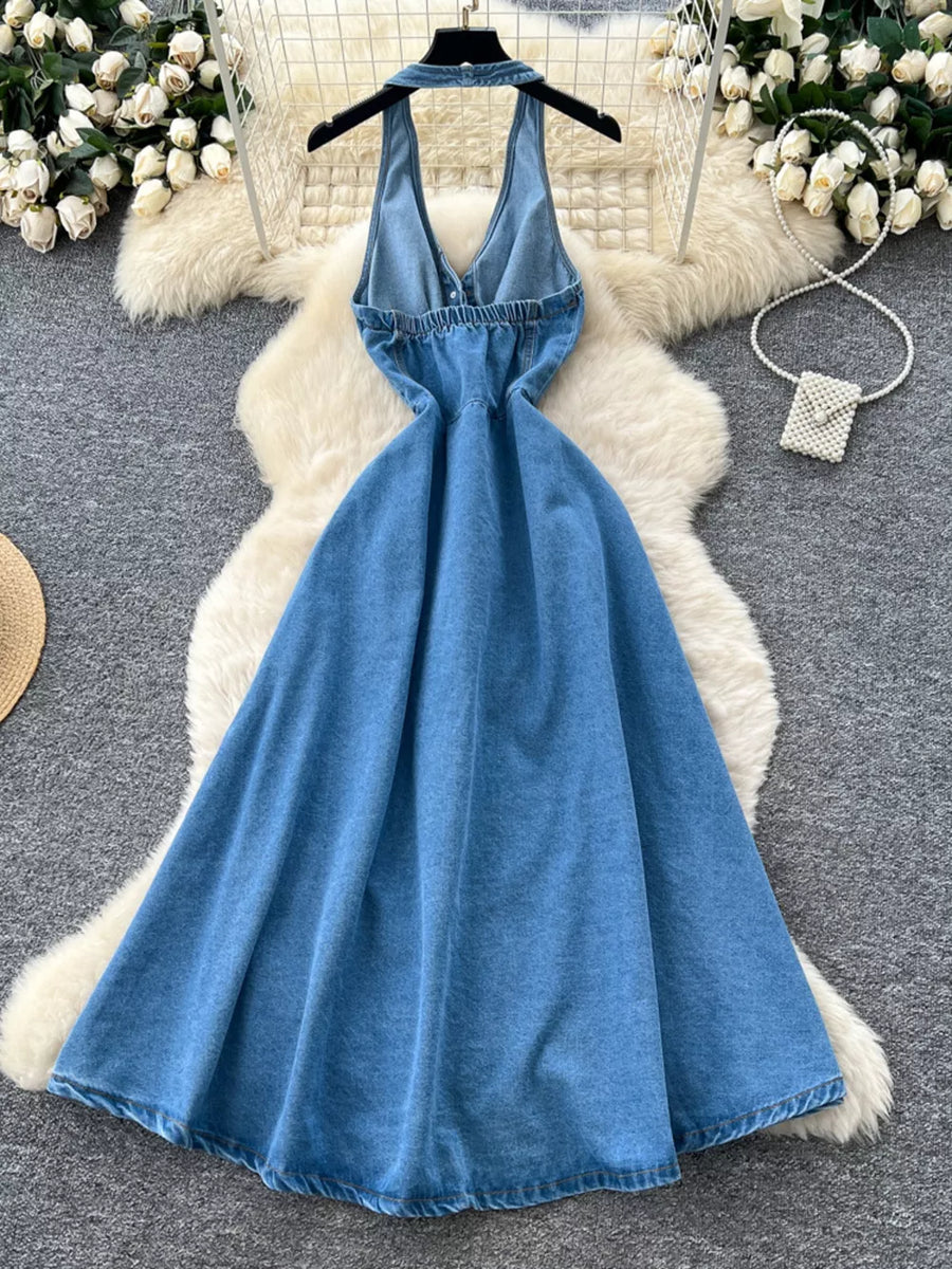 Blue denim A-line dress with V-neck, halter straps, and button placket detail.