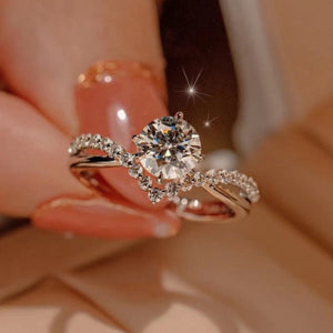 Sterling silver ring with round moissanite and accent stones, V-shaped band.