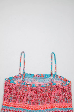 Bohemian floral maxi dress with smocked bodice, spaghetti straps, and vibrant pink, orange, and blue print.