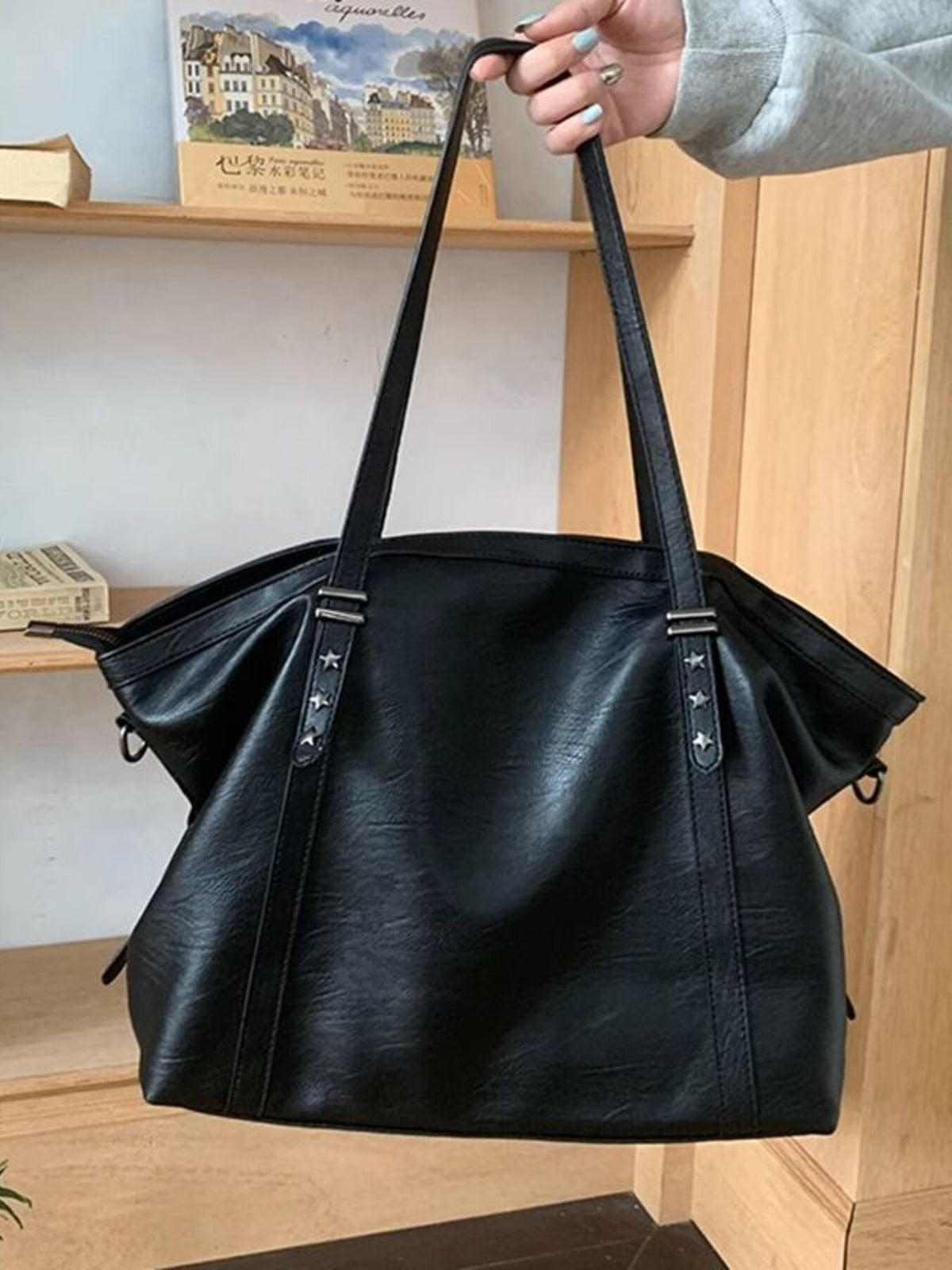 Black pu leather tote bag with star stud details and double straps.