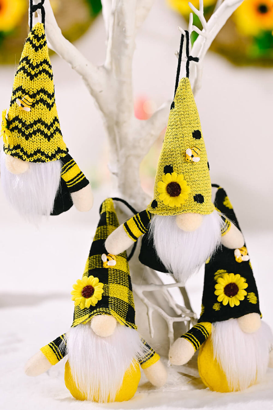 Bee-themed gnome ornaments in yellow with sunflowers and bee accents, featuring white beards and striped sleeves.